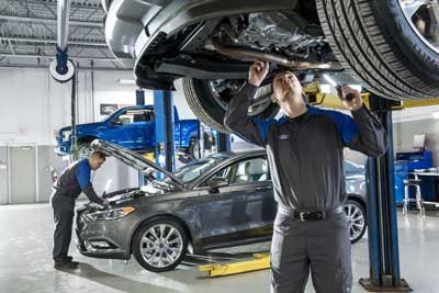 Mechanic working beneath a vehicle lift