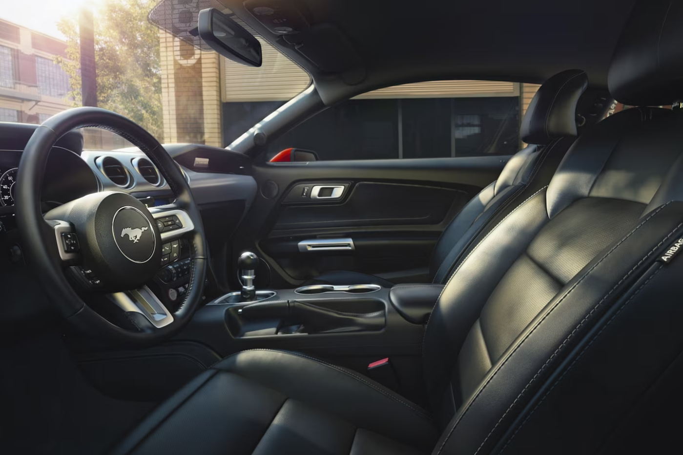 The black leather upholstered seating and all black cabin of a 2023 Ford Mustang