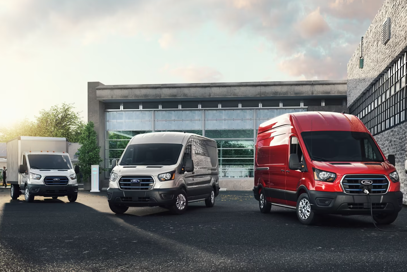 Three 2023 Ford E-Series Vans parked in front of a commercial building