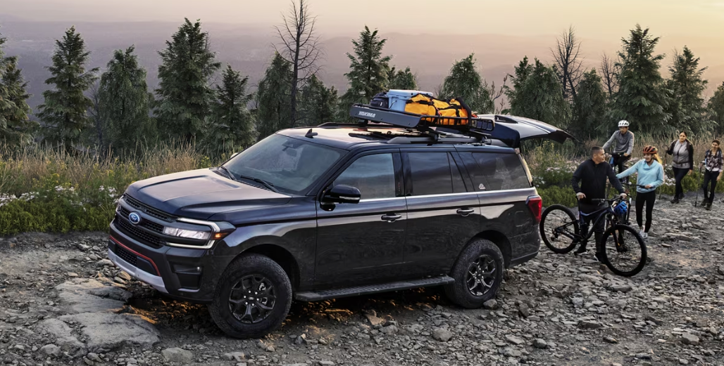 A black 2024 Ford Expedition parked in the mountain with a family