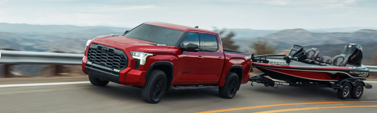 A v-formation of different colored 2023 Ford F-150s on a desert plain.