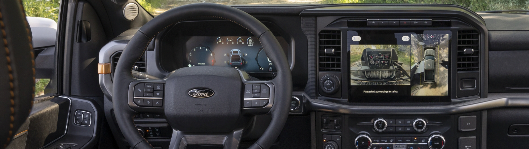 A v-formation of different colored 2023 Ford F-150s on a desert plain.