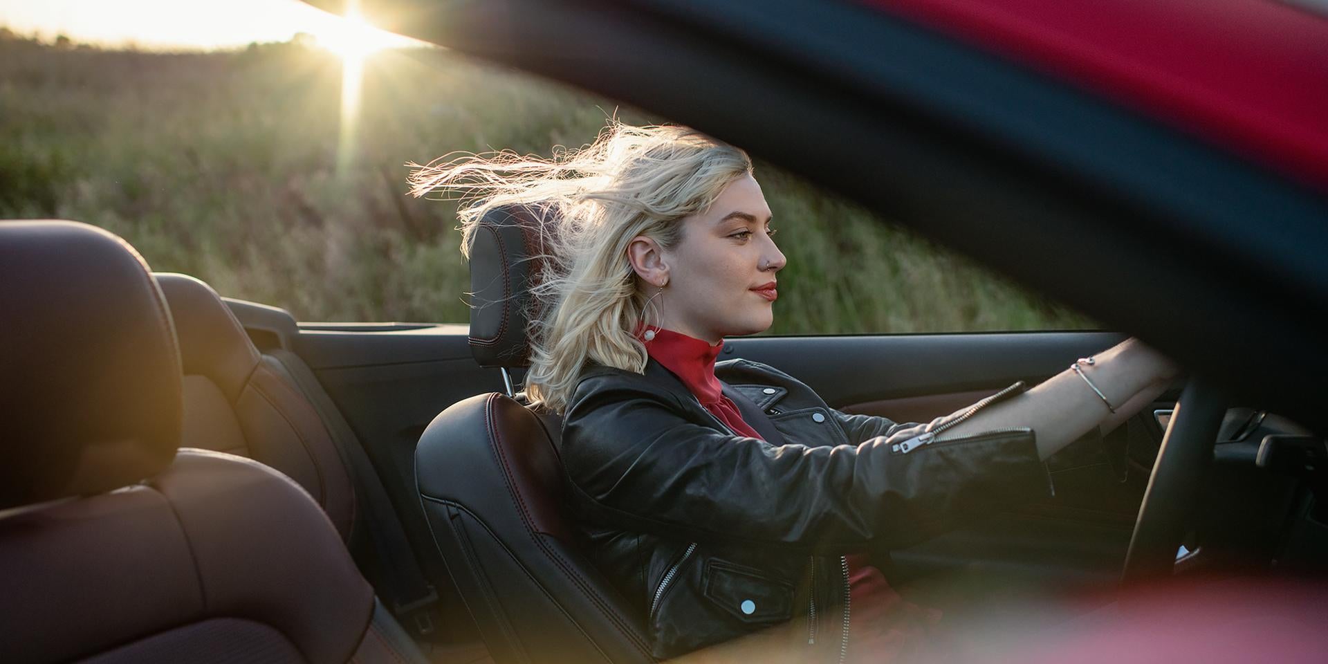 Blonde woman driving a convertible 2026 Ford Mustang